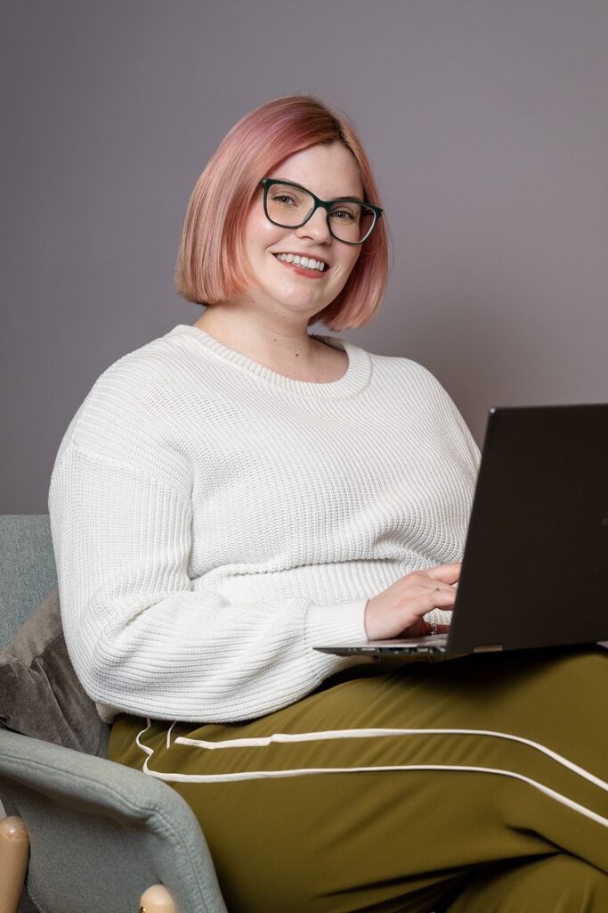 Charlotte sitting on chair with laptop