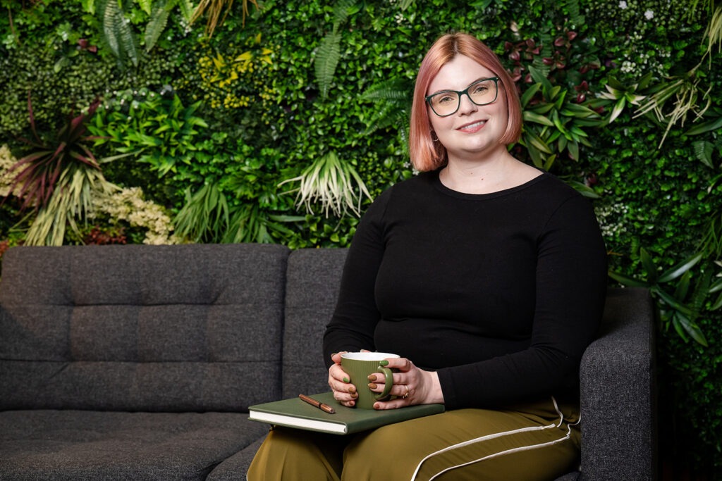 Charlotte sitting on a sofa with a mug of tea