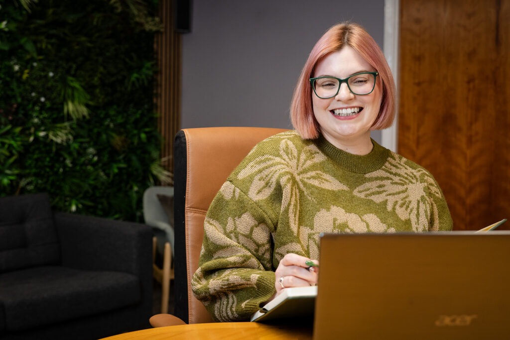 Charlotte sitting at her desk with a laptop